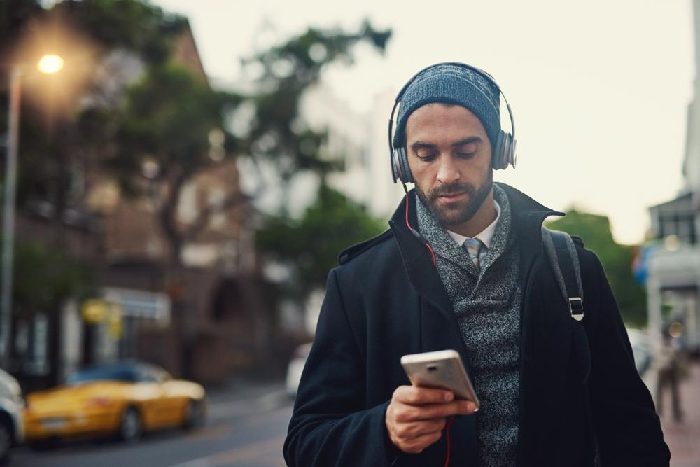 Man listening to podcast via smartphone